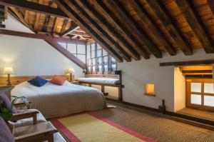 帕坦帕坦旅馆的一间带一张床的卧室,位于带木制天花板的房间内