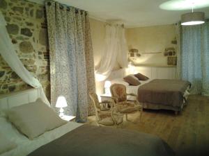 Bazoges-en-PaillersLe Manoir "Aux Douves"的酒店客房,配有两张床和椅子