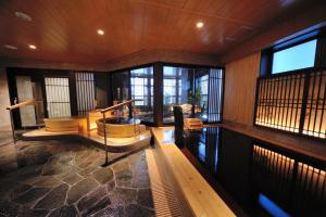 富山富山御宿野乃天然温泉经济型酒店的客厅设有木墙和窗户。