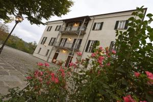 蒙多维Villa Durando的一座大型白色建筑,设有阳台和粉红色玫瑰