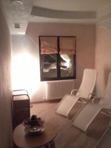 利扎诺-因贝尔韦代雷米拉瓦尔2000酒店的客厅配有2把白色椅子和桌子
