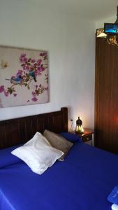 洛斯卡尼奥斯德梅卡Barlovento Tres, Los Caños的卧室配有一张蓝色的床,墙上挂着一幅画