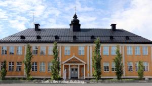 哈帕兰达Svefi Vandrarhem - Hostel的一座大型橙色建筑,屋顶黑色