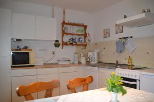RamspauFerienwohnung Seebauer的厨房配有桌子和两把椅子