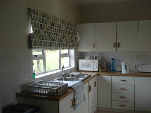 里弗斯代尔Lalani B&B/Self catering Cottages的厨房设有水槽和窗户。
