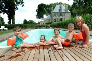 马尼库尔Château de Planchevienne的一群儿童坐在游泳池旁