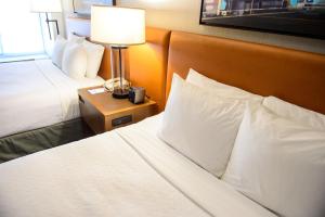 赫恩登Crowne Plaza Dulles Airport, an IHG Hotel的酒店客房设有两张床和床头灯。