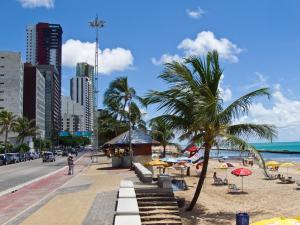 累西腓Flat em Boa Viagem的海滩上设有椅子和遮阳伞,还有大海