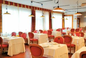 阿尔贝罗贝洛拉秋莎切蒂大酒店的用餐室配有白色的桌子和红色的椅子
