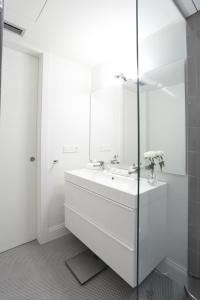 赫罗纳Apartaments Plaça Del Vi的白色的浴室设有水槽和镜子