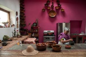 瓦曼特拉Hacienda Santa Barbara Casa Malinche的站在厨房里,有锅碗瓢盆的女人