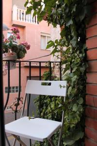 特鲁埃尔阿曼特斯德特鲁埃尔旅馆的白色椅子,坐在带鲜花的阳台