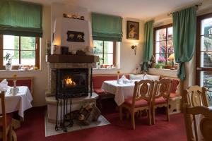 永斯多夫Romantik Hotel Zum Lindengarten的一间带壁炉和桌椅的餐厅