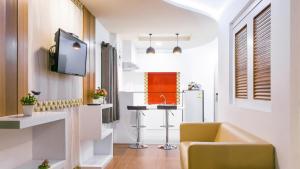 曼谷品克劳日落公寓的一个带水槽的厨房和客房内的电视