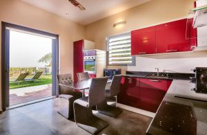 圣皮埃尔五色科菲度假屋的厨房配有红色橱柜和桌椅