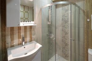内塞伯尔Aparthotel Paradiso的带淋浴、水槽和镜子的浴室