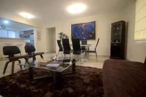 利马Luxury Apartments Miraflores的客厅配有玻璃桌和椅子