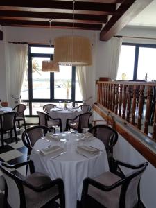 福尔内利斯Hostal S'Algaret的用餐室设有桌椅和窗户。