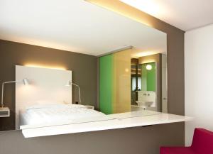 拉格斯索思丽餐厅酒店的一间卧室配有一张床和镜子