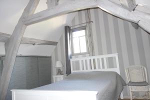 翁弗勒尔Boudin Cottage Honfleur的卧室配有白色的床和窗户。