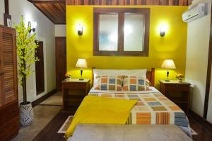 帕拉蒂Pousada Dom Angelo的黄色卧室,配有床和2个床头柜