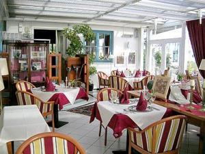 普特布斯Landhotel Kastanienallee Putbus的餐厅配有桌椅和红色餐巾