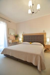 巴拉利亚-阿亚斯弗坦恩Ilioxenia Chios Studios & Apartments的白色卧室配有一张大床和吊灯