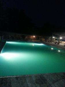 Licciana NardiResidence Le Fontane的游泳池在晚上提供绿色照明