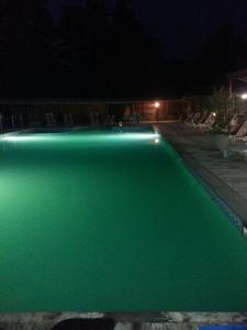 Licciana NardiResidence Le Fontane的夜间游泳池,带绿色照明