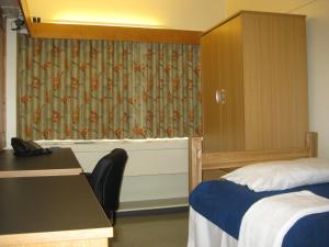 多伦多多伦多大学威尔逊霍尔酒店的配有床、书桌和窗帘的房间