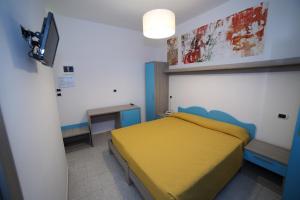 托雷瓦多奥巴特瑞酒店的一间卧室配有黄色的床和电视
