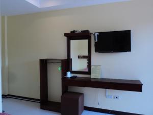 邦劳绿色原野旅游宾馆的一间设有镜子的客房,墙上配有电视