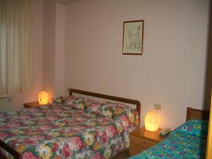 Preci意大利餐厅菲奥雷酒店的一间卧室配有一张床和一张桌子上的两个灯