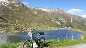 伊施格尔Hotel Garni Valülla的停在山里的一个湖泊旁的自行车