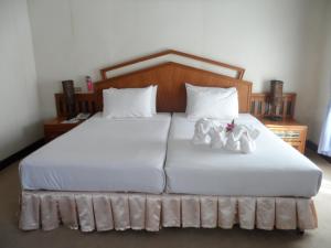 湄宏颂彩虹小木屋酒店的一间卧室,床上有白色的鞋