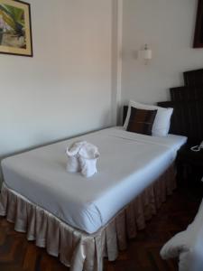 湄宏颂彩虹小木屋酒店的一张白色的大床,上面有两条白色毛巾