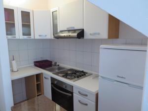 德雷斯Apartment Frano的白色的厨房设有水槽和炉灶。