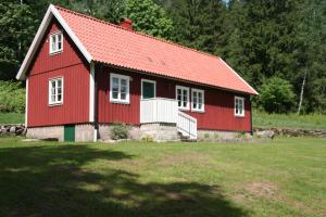 SvartråWråen Svartrå的红色的房子,在田野上有一个红色屋顶