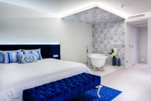 波尔图波尔图水晶酒店的一间卧室设有一张大床和一个浴缸