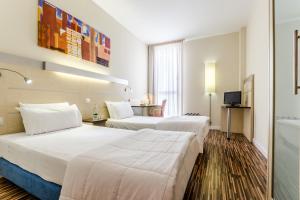 萨拉戈萨YIT萨拉戈萨酒店的酒店客房设有两张床和一张桌子。