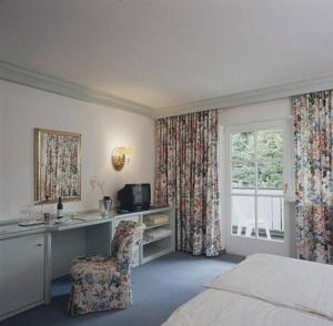 Loibichl西霍夫酒店的一间卧室配有一张床、一张桌子和一把椅子