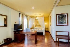 布尔戈斯阿索弗拉酒店的客房设有一张桌子、一张床和一台电视