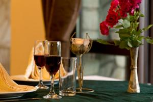 大特尔诺沃特拉兹尼酒店的一张桌子,上面放着两杯葡萄酒和一瓶玫瑰花