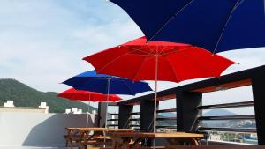 丽水市苏茜膳食度假屋的大楼顶部的三张桌子和雨伞