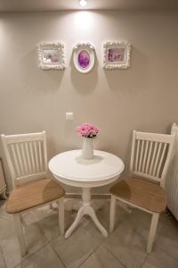 雷夫卡达镇莱夫卡迪奥公寓式酒店的一张带两把椅子的白色桌子和一个花瓶
