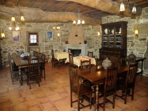 Casarellos卡萨瑞洛斯酒店的一间带桌椅和石墙的用餐室