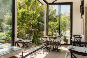 里斯本巴朗住宿加早餐旅馆的餐厅设有桌椅和大窗户。