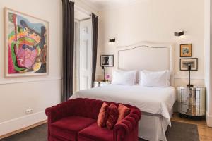 里斯本巴朗住宿加早餐旅馆的一间卧室配有一张床和一张红色椅子