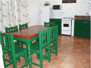 科塔德拉斯Cabañas Calma Chicha的厨房里摆放着绿色的桌椅