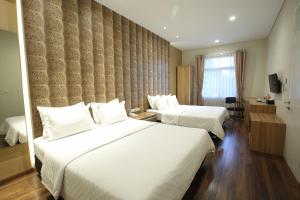 万隆达戈207号旅馆的酒店客房设有两张床和窗户。